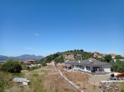 Zástavba ve vesnici pod vrcholem kopce s troskami antického města.